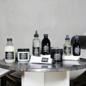 Hand holding Davines 8.45 fl oz jar to show scale and convenience