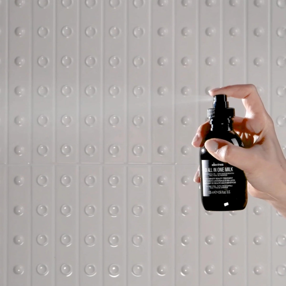 Davines OI product in use smoothing hair showing reduced frizz and glossy finish benefit