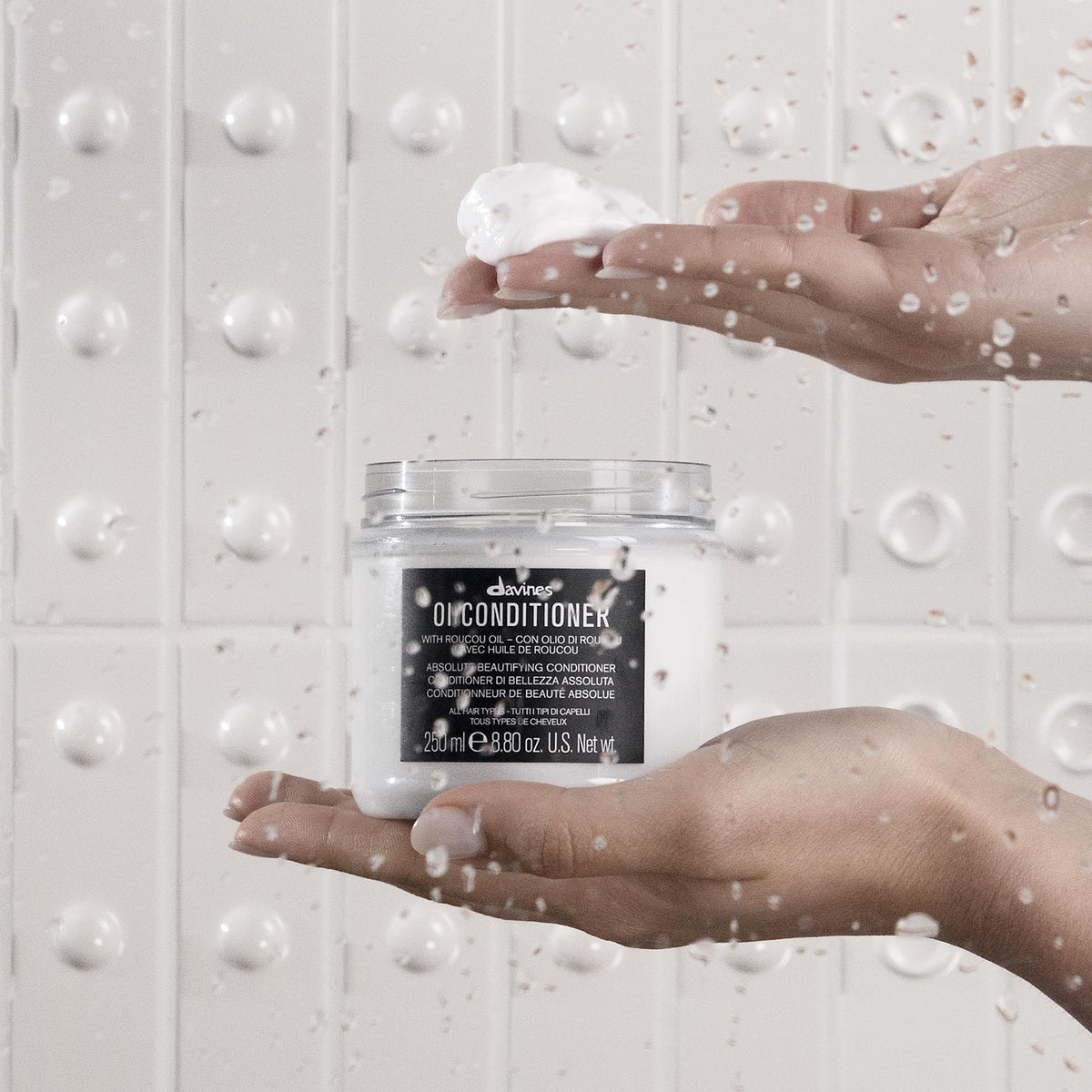Davines OI milk dispensing pump shot showing easy application with protective layer benefit
