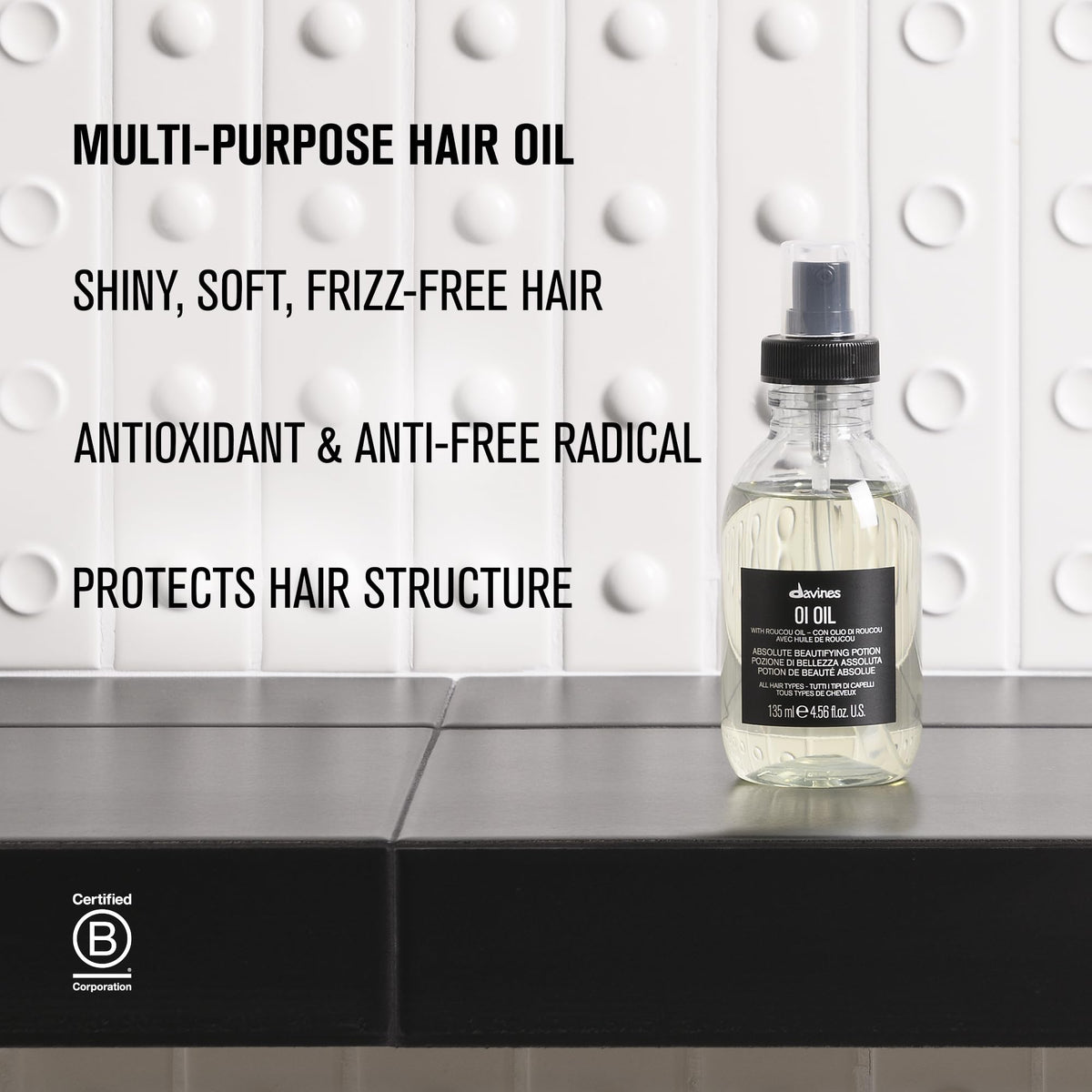 Davines OI Oil travel size beside toiletries for on-the-go styling ease