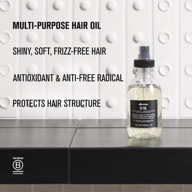 Davines OI Oil travel size beside toiletries for on-the-go styling ease
