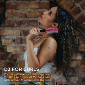 Hand holding Denman D3 demonstrating ergonomic tear-drop handle for better control
