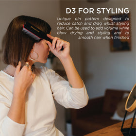 Denman brush being used on damp hair to shape and define curls with tension