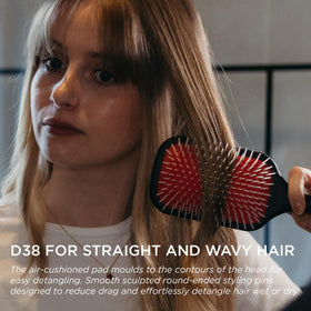 Denman brush held in hand showing scale and comfortable ergonomic grip