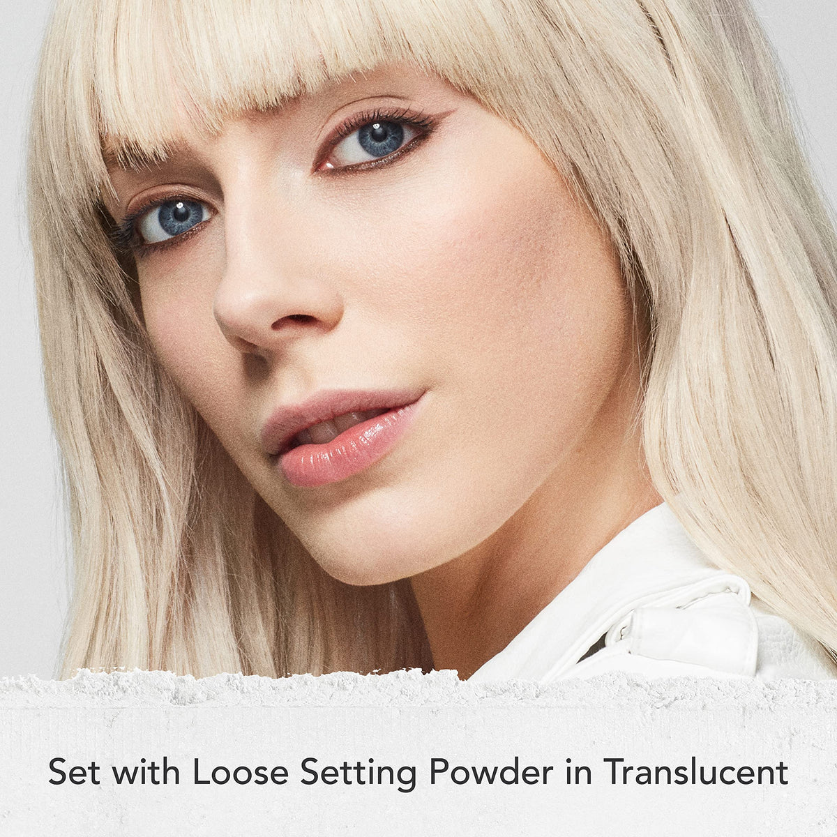 Dermablend loose powder applying with a fluffy brush for longwear mattifying benefit