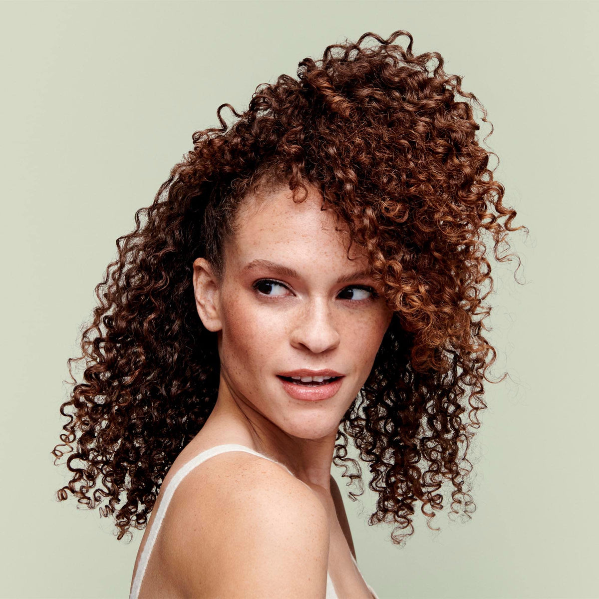 DevaCurl cleanser applied to wet curls illustrating gentle cleansing and frizz control