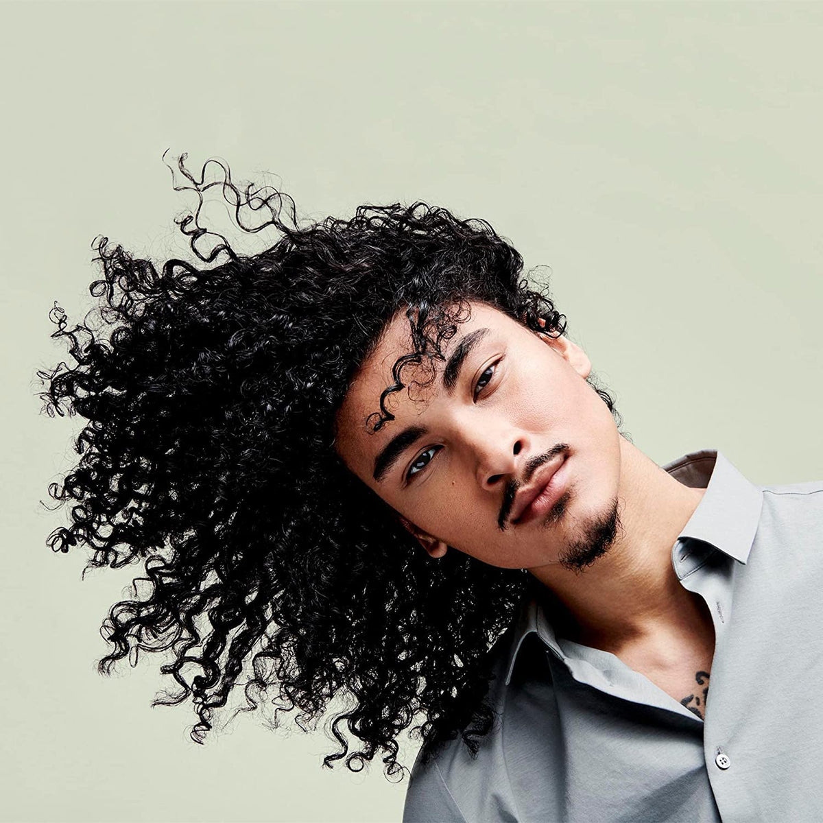 DevaCurl bottle held in hand for size comparison and portable styling convenience on-the-go