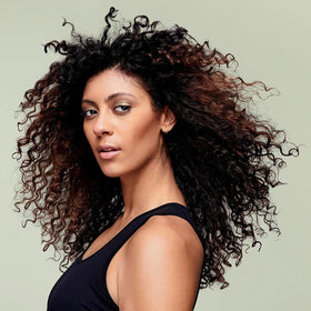 DevaCurl label close-up highlighting ingredient claims and dermatologist-developed formulation benefits