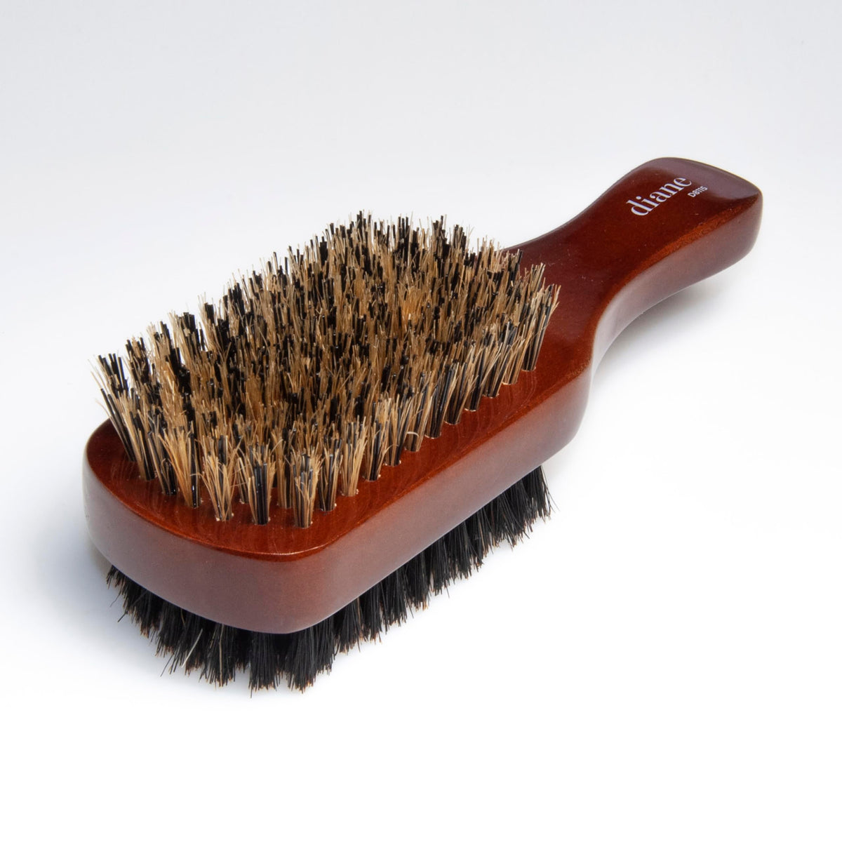 Diane brush held in hand to show compact scale and easy palm control