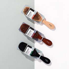 Diane brush beside a hand to show compact size and comfortable ergonomic control