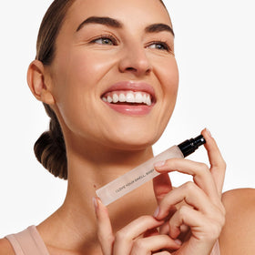 DIME travel spray held in hand to show size and convenience for on-the-go use