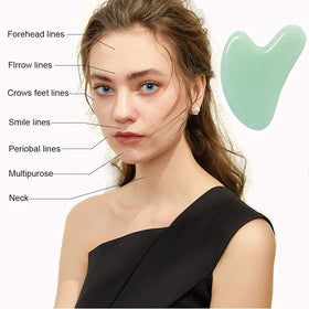 Ditind gua sha held in hand showing scale and ergonomic benefit