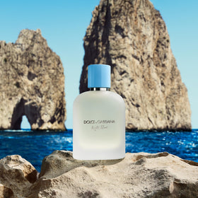 Lifestyle scene with Dolce&Gabbana on a coastal table evoking Capri freshness and travel vibes