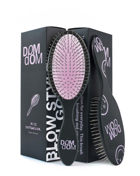 Dom Dom detangling brush front view showing compact design and easy grip benefit