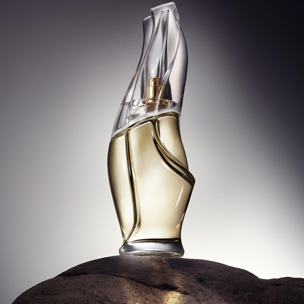 Donna Karan bottle on cashmere fabric emphasizing soft texture and benefit of cozy warmth