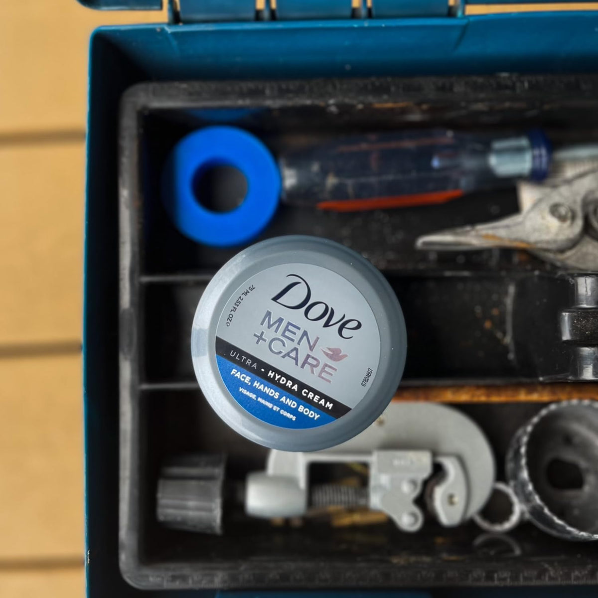Dove Men+Care jar in a hand for scale emphasizing portable convenience