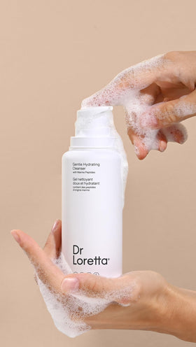 Dr. Loretta bottle next to hand for scale, shows travel-friendly size