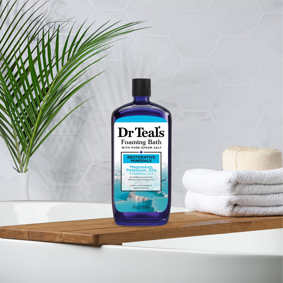 Hand holding Dr Teal's bottle next to tub, indicates 34 fl oz size and scale