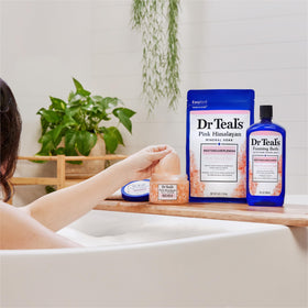 Dr Teal's scrub styled in a ceramic bowl on bath shelf conveying relaxing self-care