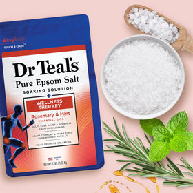 Hand holding Dr Teal's 3 lb container for scale, benefit of easy home use