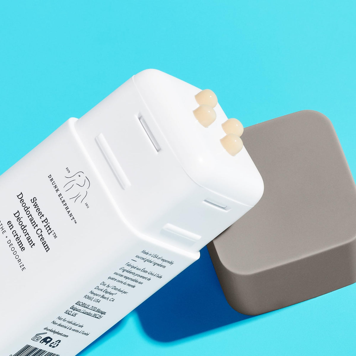 Drunk Elephant open jar with fingertip applying cream demonstrating easy use