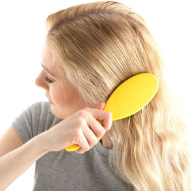 Drybar Super Lemon Drop held in hand to show scale and slip-free handle for controlled brushing