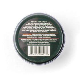 Duke Cannon beard balm applied during grooming to tame and soften beard
