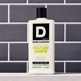Duke Cannon bottle next to hand for 14 oz size and scale clarity