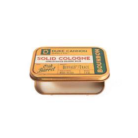 Duke Cannon bourbon solid cologne tin on wood surface conveying oak-inspired scent