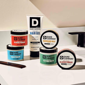 Duke Cannon pomade on bathroom shelf in lifestyle setting suggesting daily grooming routine