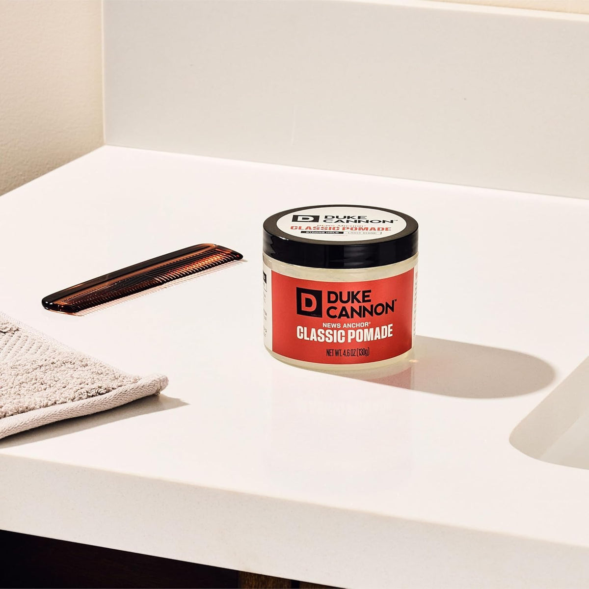 Duke Cannon jar beside a ruler showing 4.6 oz size for travel-friendly convenience
