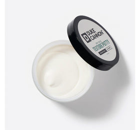 Duke Cannon hands applying putty demonstrating easy warming and spread benefit