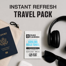 Duke Cannon towel next to hand and phone illustrating compact size and easy carry