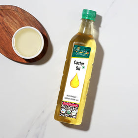 Model applying Dwaraka castor oil to hair roots for improved manageability and strength