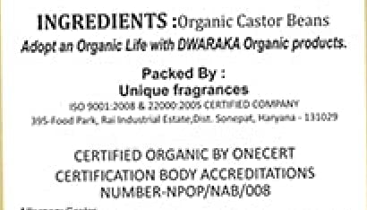 Dwaraka castor oil bottle next to measuring cup showing 500 ml scale and usage guidance