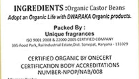 Dwaraka castor oil bottle next to measuring cup showing 500 ml scale and usage guidance