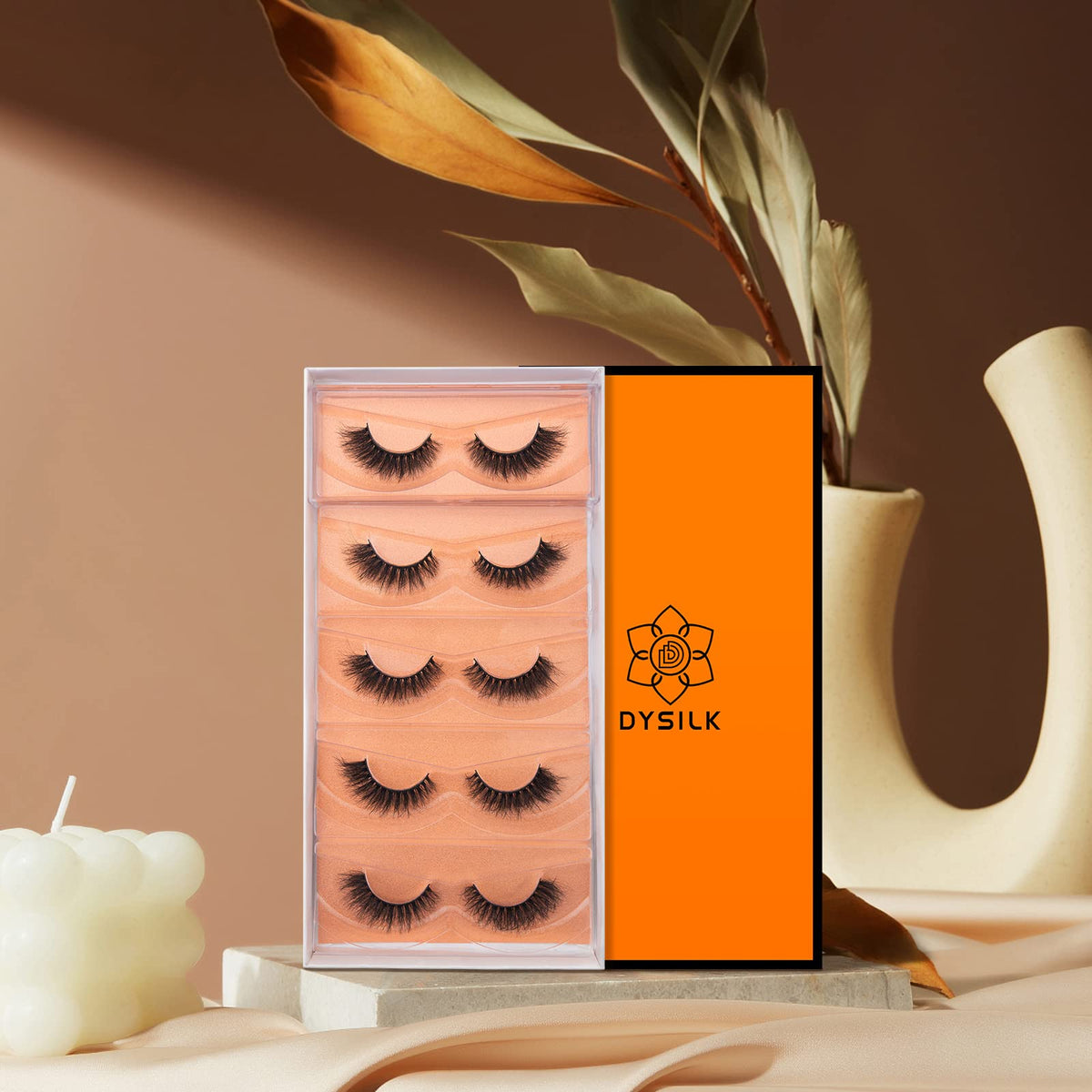 DYSILK lashes in hand demonstrating travel-friendly compact kit