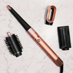 Model using Dyson Airwrap i.d. to curl hair showcasing effortless heat‑free shaping