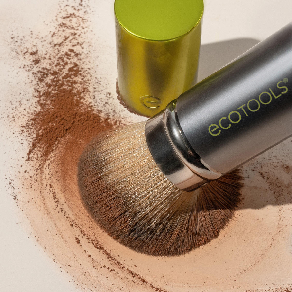 EcoTools brush applying powder on cheek for even coverage and natural finish