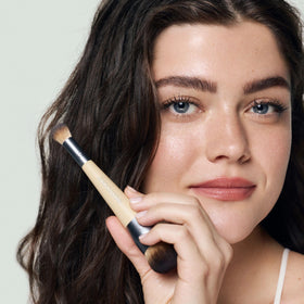 EcoTools brush next to liquid foundation illustrating how to buff evenly