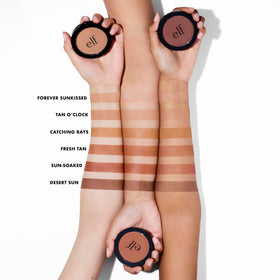 e.l.f. primer-infused bronzer being applied with a fluffy brush for natural warmth