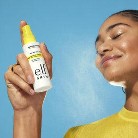 e.l.f. SKIN being sprayed over foundation for makeup-safe SPF reapplication