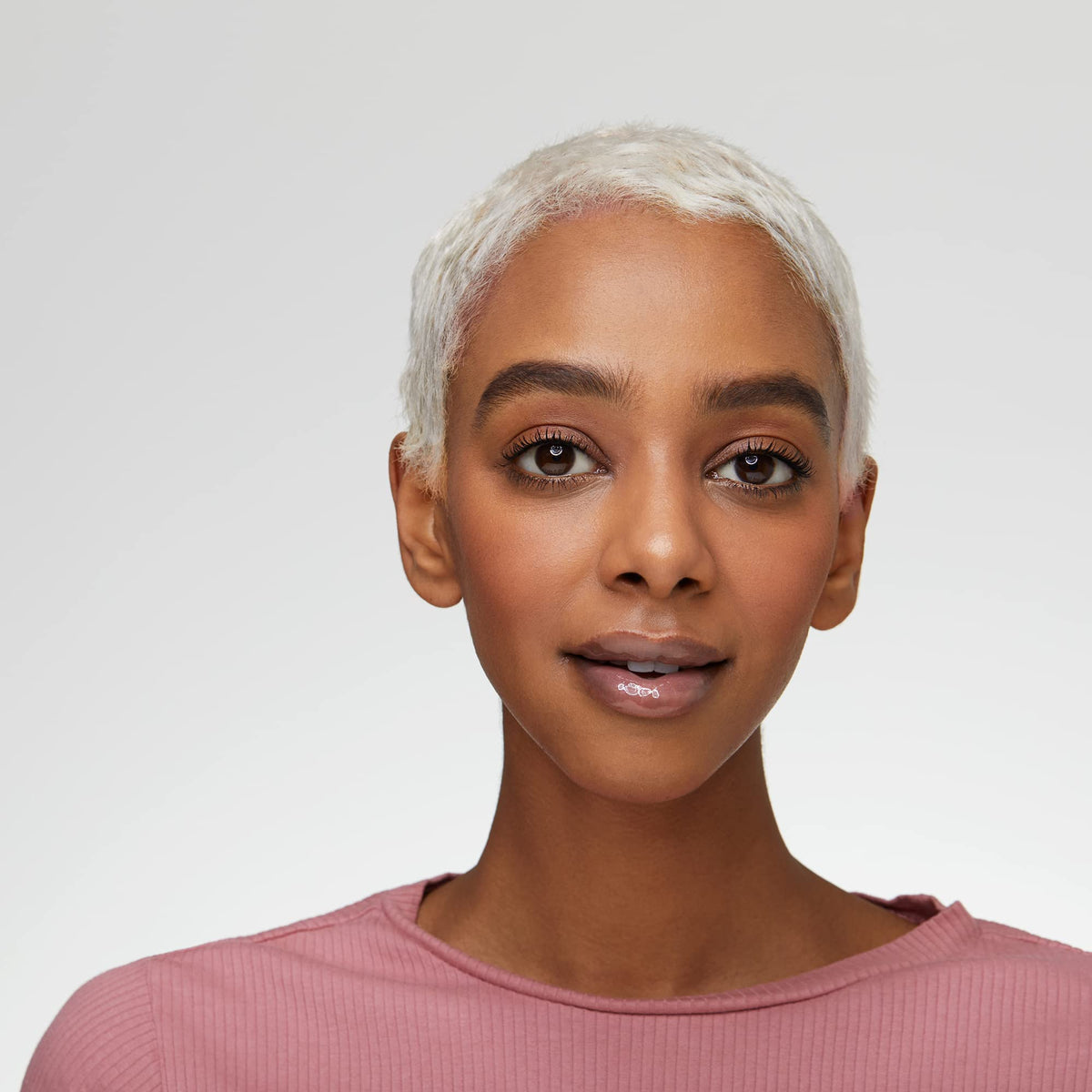 essence model applying gloss to lips for instant volume and high shine