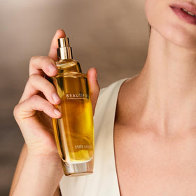 Estée Lauder Beautiful 3.4 oz bottle next to everyday objects for size and scale clarity