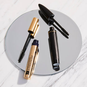 Estée Lauder mascara size comparison with coin emphasizes compact travel convenience