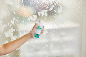 Person using Exederm in shower illustrating soothing scalp care