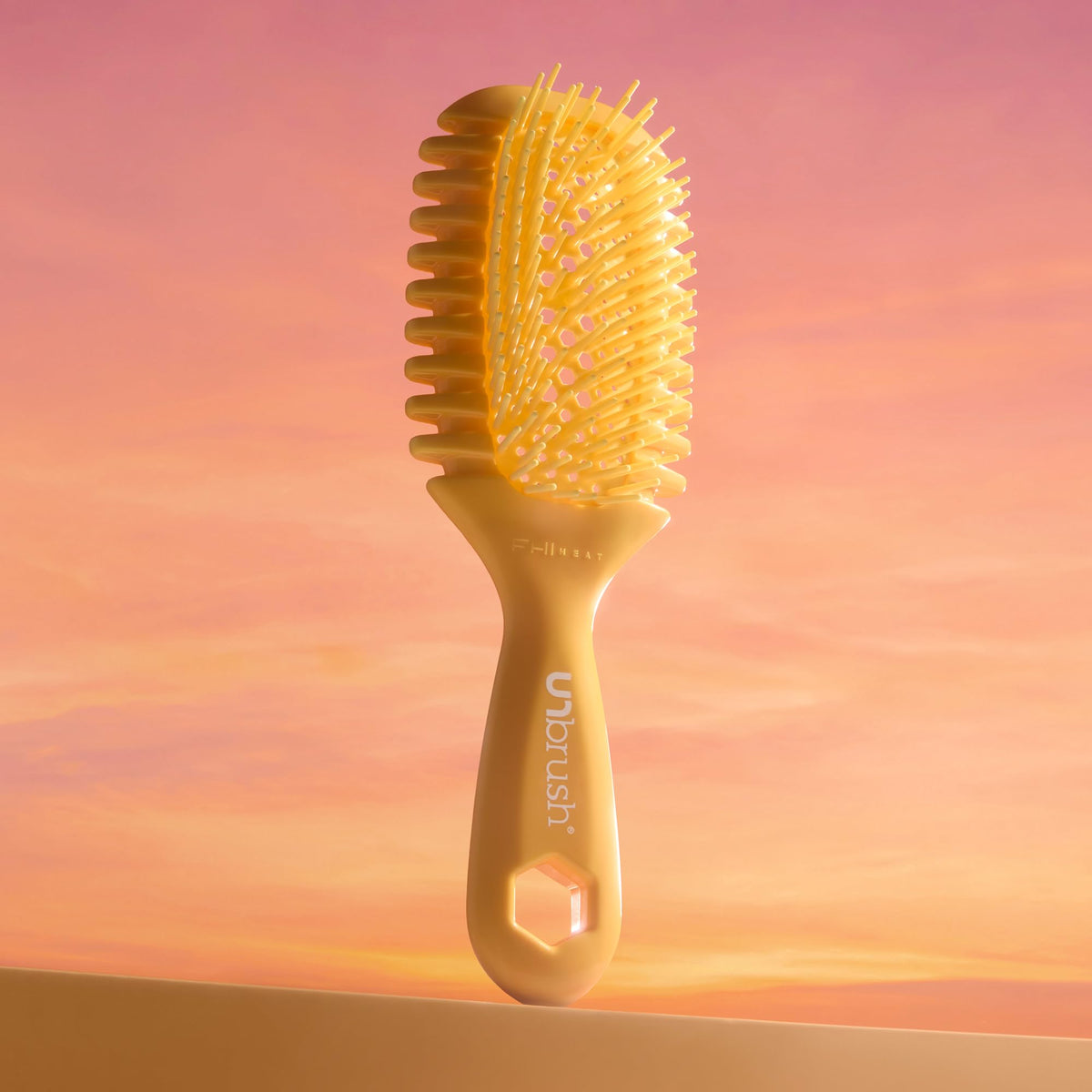 FHI Heat UNbrush Curl held in hand to show scale and lightweight 1.5 oz handling
