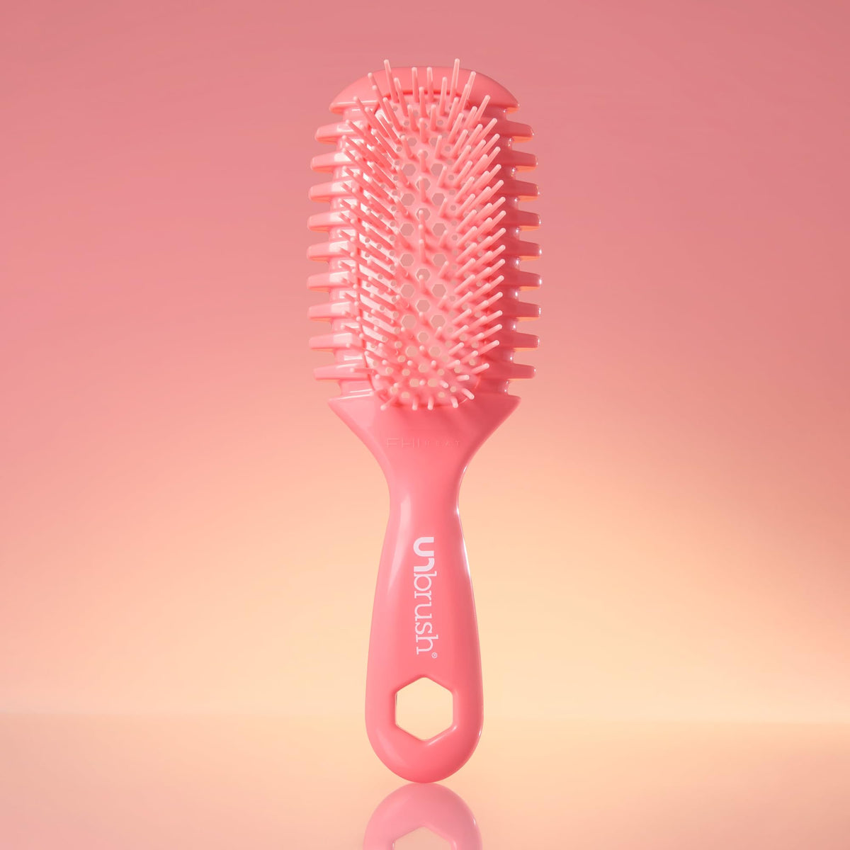 FHI Heat brush next to a hand to show compact size and easy maneuverability