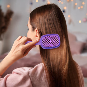 FHI Heat UNbrush mini in hand to show lightweight 1.2 oz handle and easy control