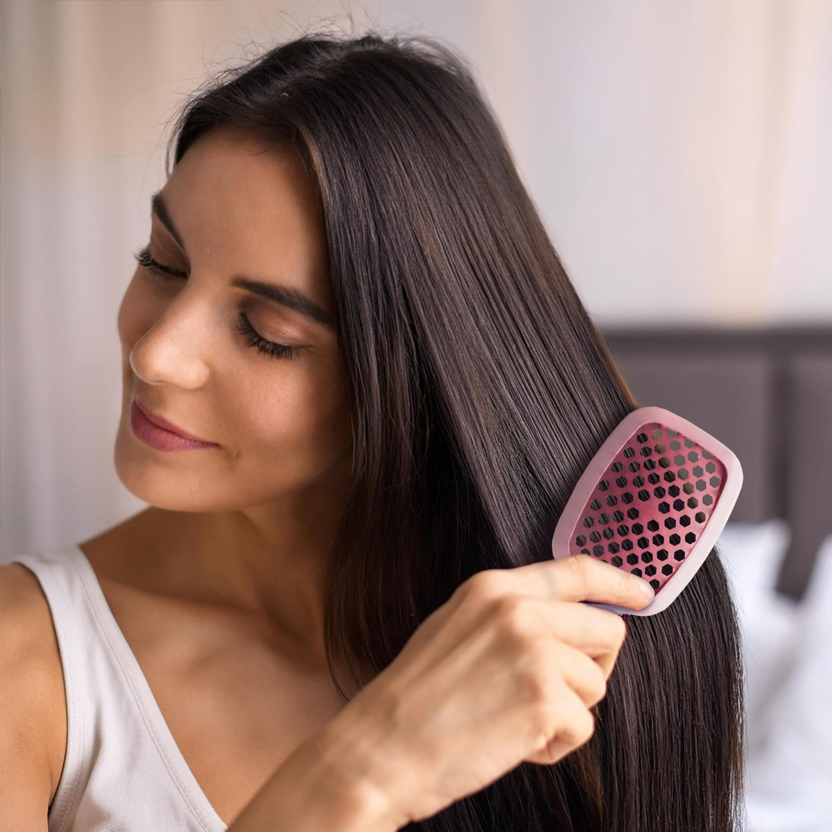 FHI Heat UNbrush Mini held in hand demonstrating lightweight 1.2 oz handle for easy control